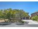 Attractive home showcasing a neat front yard with mature trees and a long concrete driveway at 5716 Breckenridge St, North Las Vegas, NV 89081
