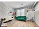 Versatile room with modern furniture, white and green couches, decor, and natural light at 5716 Breckenridge St, North Las Vegas, NV 89081
