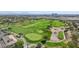 Stunning aerial view of golf course with manicured greens, sand traps, and mature trees with clubhouse and city skyline background at 613 Pinnacle Heights Ln, Las Vegas, NV 89144