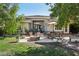 Lush backyard with a covered patio, dining area, and fire pit, ideal for entertaining and relaxation at 613 Pinnacle Heights Ln, Las Vegas, NV 89144