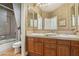 Bathroom with double sink vanity, warm toned tile and fixtures, and shower at 613 Pinnacle Heights Ln, Las Vegas, NV 89144