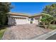 Charming home featuring a paver driveway, lush landscaping, and an attached two-car garage at 613 Pinnacle Heights Ln, Las Vegas, NV 89144