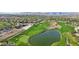 Overhead capture of a golf course featuring a lake, sand traps, surrounding lush green, and clear blue skies at 613 Pinnacle Heights Ln, Las Vegas, NV 89144