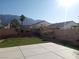 Large backyard with artificial grass, mature trees, and stunning mountain views at 6449 Elizabethtown Ave, Las Vegas, NV 89110