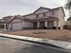 Two-story home featuring a three car garage, tile roof, and a low maintenance front yard at 6449 Elizabethtown Ave, Las Vegas, NV 89110