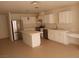 Bright kitchen with white cabinets, stainless steel appliances, and a functional island with white quartz countertops at 6449 Elizabethtown Ave, Las Vegas, NV 89110