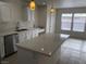 Bright kitchen with white cabinets, stainless steel appliances, and large island with white quartz countertops at 6449 Elizabethtown Ave, Las Vegas, NV 89110