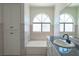 Bathroom featuring a tub and shower combination, and a large arched window at 6601 W Pepperidge Way, Las Vegas, NV 89108