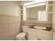 The half bathroom features neutral tiling, a decorative mirror, and a vanity with storage at 6601 W Pepperidge Way, Las Vegas, NV 89108
