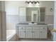 Bathroom featuring a vanity with black countertop and a large mirror at 6601 W Pepperidge Way, Las Vegas, NV 89108
