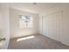 Sunny bedroom featuring neutral carpet, a large window, and a spacious closet at 6601 W Pepperidge Way, Las Vegas, NV 89108