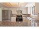 Bright kitchen with stainless steel refrigerator, granite counters, white cabinets, and updated appliances at 6601 W Pepperidge Way, Las Vegas, NV 89108