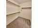 Walk-in closet features carpeted floors and wooden shelving with metal supports at 6621 Churnet Valley Ave, Las Vegas, NV 89139