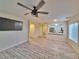 Bright and open living room with tile flooring, ceiling fan, and an open kitchen view at 6621 Churnet Valley Ave, Las Vegas, NV 89139