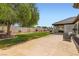 Large, well-manicured lawn with a patio, mature trees, and privacy wall at 7404 Wittig Ave, Las Vegas, NV 89131