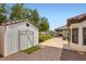 Backyard featuring white storage shed, lush lawn, covered patio, and view of the pool at 7404 Wittig Ave, Las Vegas, NV 89131