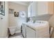 Clean laundry room with washer, dryer, ample cabinetry, and decorative wall art at 7404 Wittig Ave, Las Vegas, NV 89131