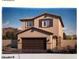 Inviting two-story home with a two-car garage and desert landscaping at 7430 Bo Gable Falls Pl # 54, North Las Vegas, NV 89084