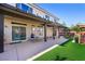 Beautiful backyard with a covered patio, table, a small patch of artificial turf and a two-story home exterior at 10042 Pipestone St, Las Vegas, NV 89141