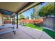 Backyard features artificial turf, a seating area with awning, a storage shed, and patio space at 10042 Pipestone St, Las Vegas, NV 89141