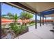 Inviting backyard features a seating area with covering, turf, well manicured plants, and partial perimeter wall at 10042 Pipestone St, Las Vegas, NV 89141