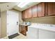Well-lit laundry room with washer, dryer, countertop and lots of cabinet space at 10042 Pipestone St, Las Vegas, NV 89141