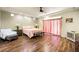 This main bedroom features wood floors, a ceiling fan, bench, and a king bed at 10042 Pipestone St, Las Vegas, NV 89141