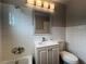 Cozy bathroom with white tile, toilet, and sink with classic fixtures and lighting at 1338 Smoke Tree Ave, Las Vegas, NV 89108
