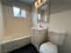 Bathroom features white tiled walls, tub, toilet, and vanity with sink at 1338 Smoke Tree Ave, Las Vegas, NV 89108
