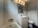 Bathroom featuring a single sink vanity, tub, and toilet with white tiles and neutral tones at 1338 Smoke Tree Ave, Las Vegas, NV 89108