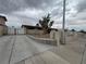 Well-maintained front exterior with a long driveway, small tree, and tan stucco exterior at 1338 Smoke Tree Ave, Las Vegas, NV 89108