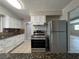 Traditional kitchen featuring stainless steel appliances, granite counters and white cabinets at 1338 Smoke Tree Ave, Las Vegas, NV 89108