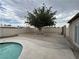 Spacious backyard featuring a refreshing pool, mature tree and concrete patio perfect for outdoor enjoyment at 1338 Smoke Tree Ave, Las Vegas, NV 89108