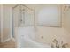 Bright bathroom featuring a soaking tub with jets, a glass-enclosed shower, and tile flooring at 1598 Cowboy Chaps Pl, Henderson, NV 89002