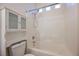 Bright bathroom featuring a tiled shower-tub combo and a white storage cabinet above the toilet at 1598 Cowboy Chaps Pl, Henderson, NV 89002