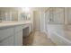 Well-lit bathroom with double vanity, soaking tub, and glass-enclosed shower for a spa-like experience at 1598 Cowboy Chaps Pl, Henderson, NV 89002