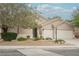 Charming home with a three-car garage, desert landscaping, and a mature tree at 1598 Cowboy Chaps Pl, Henderson, NV 89002