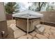 Enclosed backyard featuring a private hot tub with a shade cover and easy access steps at 1598 Cowboy Chaps Pl, Henderson, NV 89002