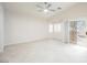 Open-concept living area with neutral tile, ceiling fan, and a sliding door to a patio at 1598 Cowboy Chaps Pl, Henderson, NV 89002