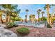 Attractive community pool area with lush landscaping, palm trees, and comfortable lounging at 2253 Van Gogh Dr, Henderson, NV 89074