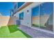 This backyard features a brick patio, artificial grass, and sliding glass doors leading inside at 2523 Campaldo St, Henderson, NV 89044