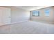 Large bedroom featuring neutral carpeting, two windows, and paneled door at 2523 Campaldo St, Henderson, NV 89044