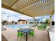 Community pool area with tables, chairs, a barbecue, and covered lounging with shade from a trellis at 2523 Campaldo St, Henderson, NV 89044