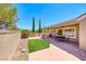 Inviting back patio with artificial turf, seating area, and views of the well-manicured backyard at 3001 Walnut Park Ct, Henderson, NV 89052