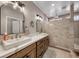 Elegant bathroom featuring double sinks, a large mirror, and a luxurious tiled shower at 3001 Walnut Park Ct, Henderson, NV 89052