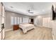 Bright main bedroom with a ceiling fan, TV and open bathroom with glass door at 3001 Walnut Park Ct, Henderson, NV 89052