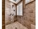 Modern tiled shower with pebble floor, bench and window with plantation shutters at 3001 Walnut Park Ct, Henderson, NV 89052