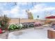 The backyard has a concrete patio, flowers, a brick wall and an outdoor dining table with an umbrella at 4542 Silver Bit Ct, North Las Vegas, NV 89032