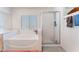 Bright bathroom featuring a soaking tub next to glass-enclosed shower stall at 4542 Silver Bit Ct, North Las Vegas, NV 89032
