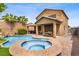 Inviting backyard featuring a sparkling pool, hot tub, covered patio, and landscaped surroundings at 7013 Bisoni St, Las Vegas, NV 89149